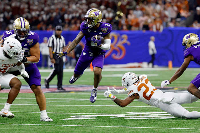 Jan 1, 2024; New Orleans, LA, USA; Washington Huskies wide receiver Ja'Lynn Polk (2) leaps over Texas Longhorns defensive back Jahdae Barron (23) during the third quarter of the 2024 Sugar Bowl college football playoff semifinal game at Caesars Superdome.
